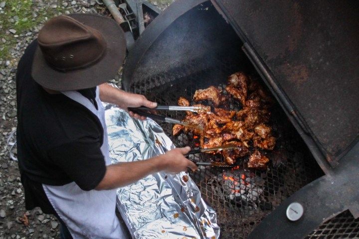 a person cooking hot dogs on a grill